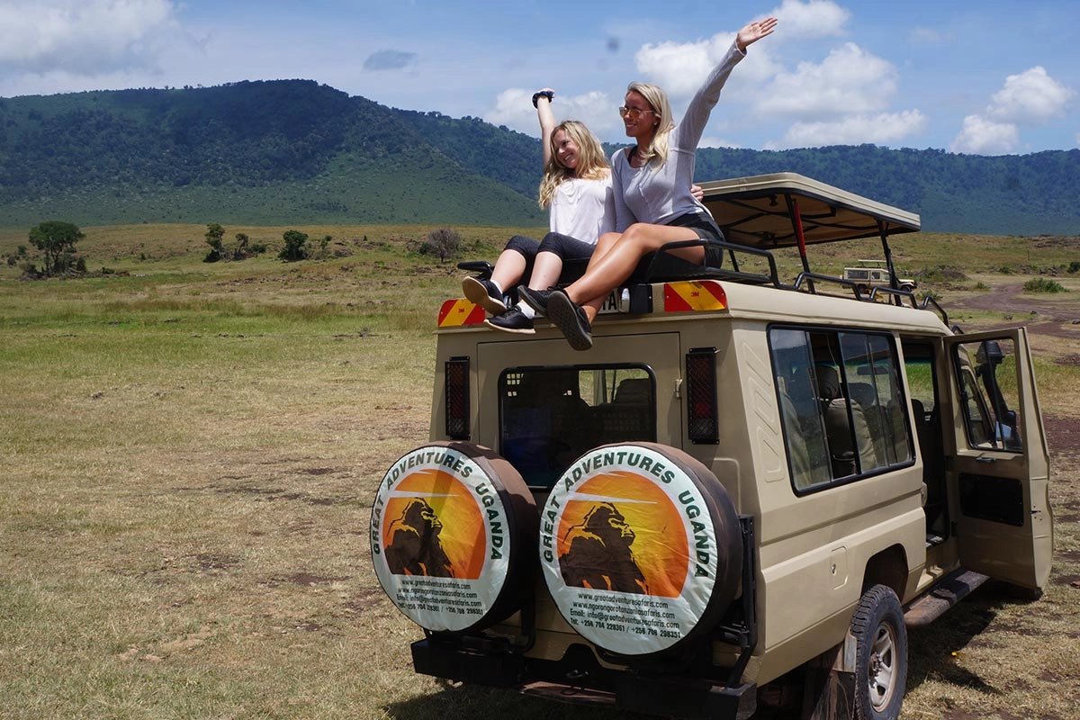 Happy tourists on safari game drive in Queen Elizabeth National Park Uganda